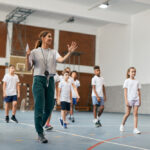 Happy,Physical,Education,Teacher,Talking,To,Her,Students,During,A