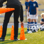 Soccer,Coach,Placing,Training,Cones,For,Kids,Sports,Team.,Children